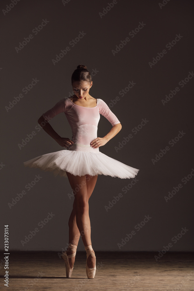 Naklejka premium Young beautiful ballerina is posing in studio