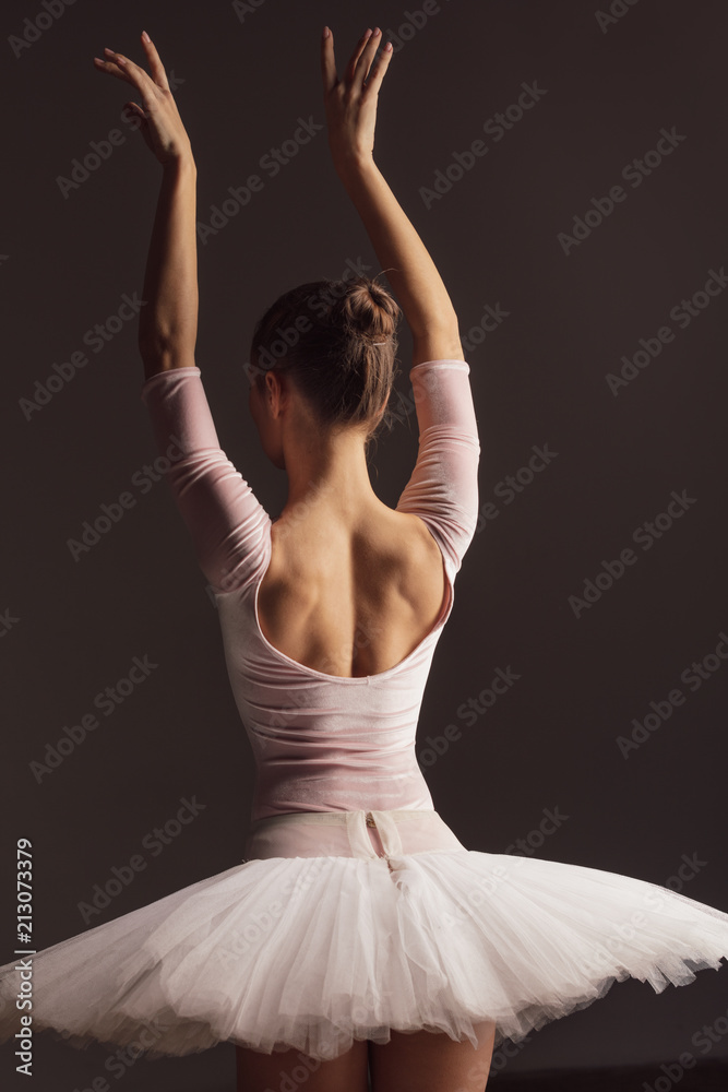 Naklejka premium Young beautiful ballerina is posing in studio