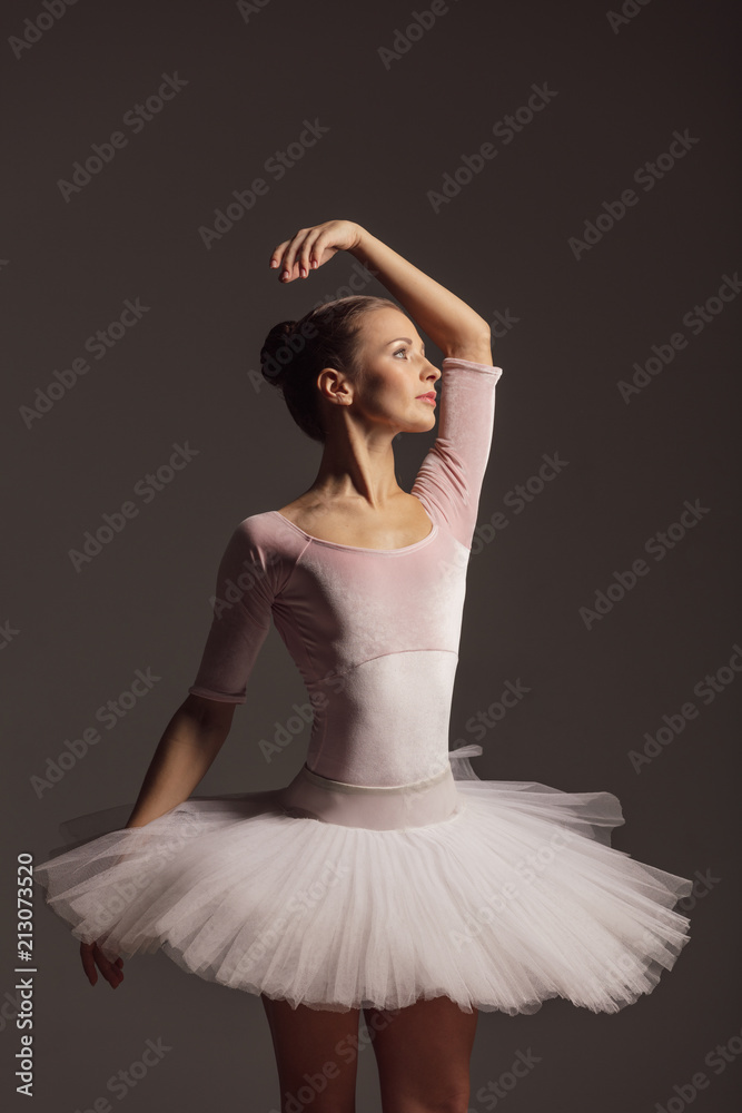 Fototapeta premium Young beautiful ballerina is posing in studio