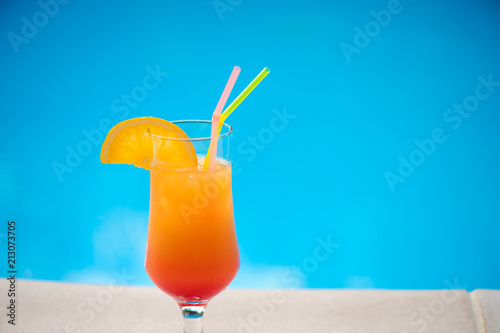 Cocktail next to swimming pool, summer vacation concept