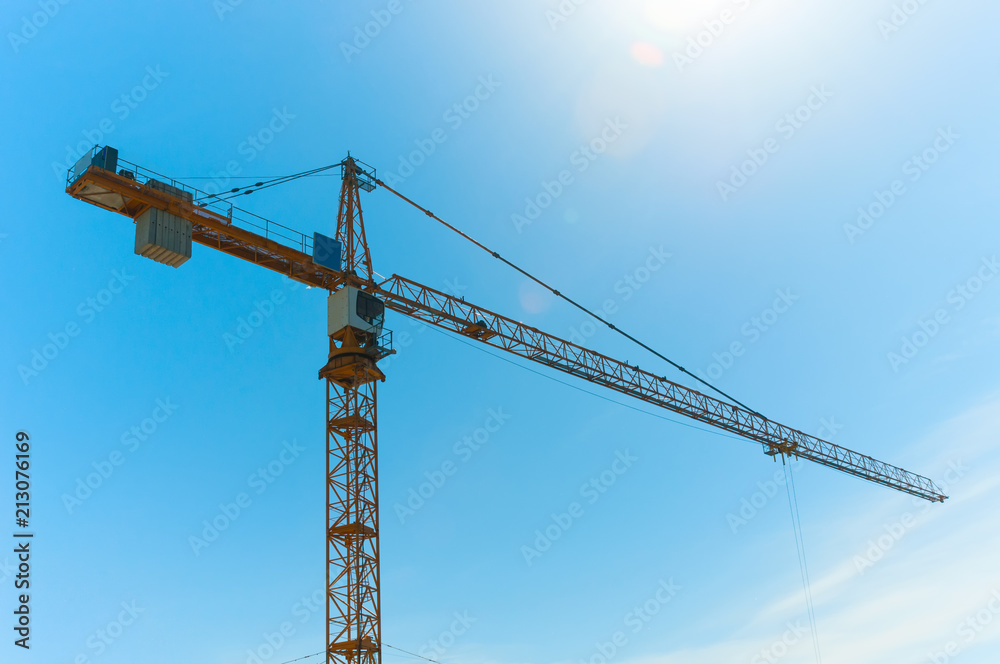 Construction crane tower against blue sky