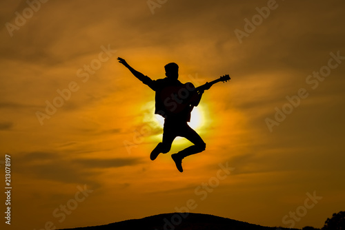 Vocals, guitar man jumping silhouette.