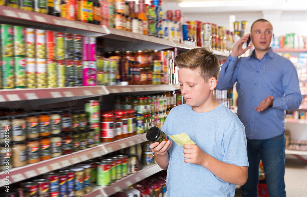Serious boy choosing products on shopping list