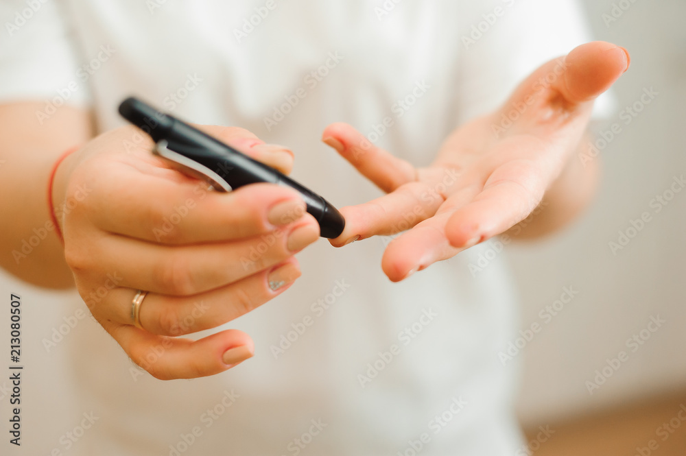 Medicine, Diabetes, Glycemia, Health care and people concept - close up of female finger with blood drop and test stripe to checking blood sugar level by Glucose meter Medicine, Diabetes, Glycemia, Health care and people concept - close up of female finger with blood drop and test stripe to checking blood sugar level by Glucose meter