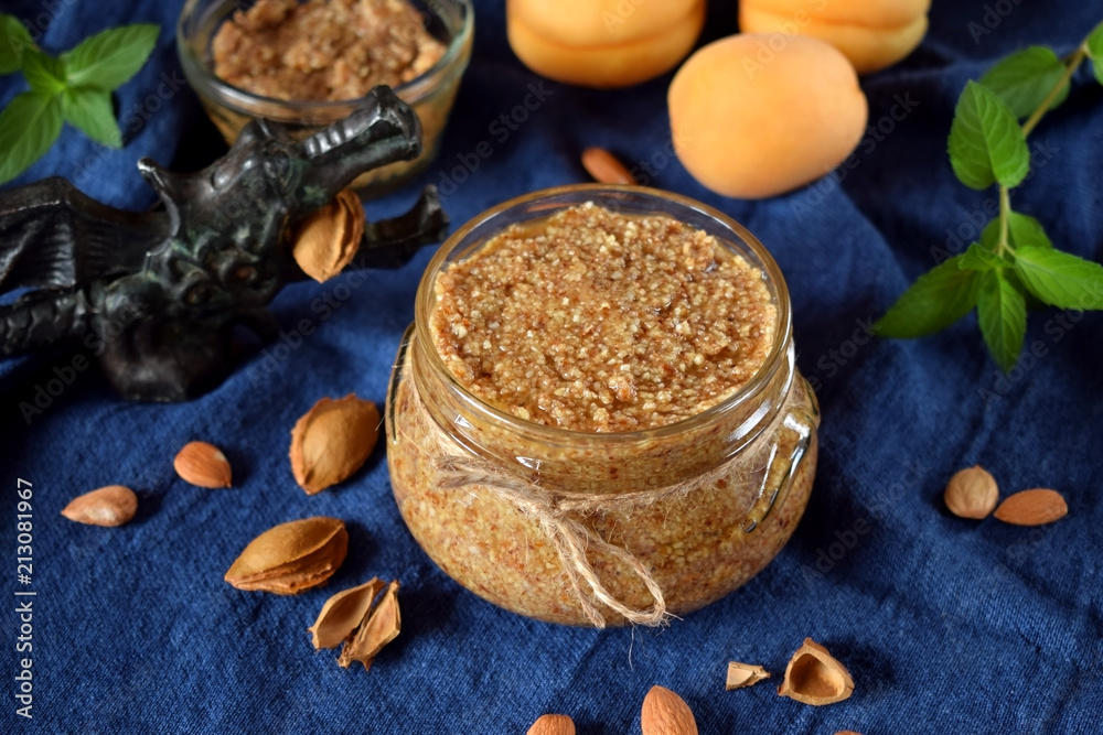 Fototapeta premium Urbech of apricot kernel in a glass jar. National Dagestani paste of nuts