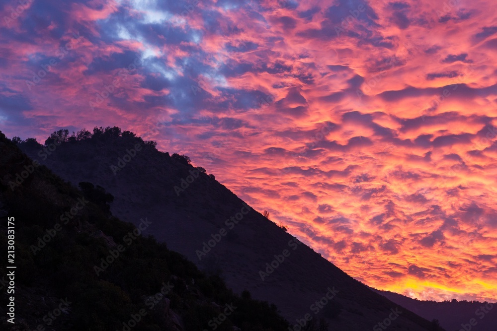 Sky of fire sunset behind the mountains in Santiago, Chile. Fabulous winter twilight in South America