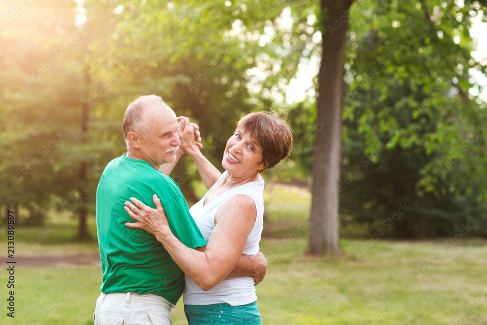 Senior couple dancing in park on sunny day Senior couple dancing in park on sunny day