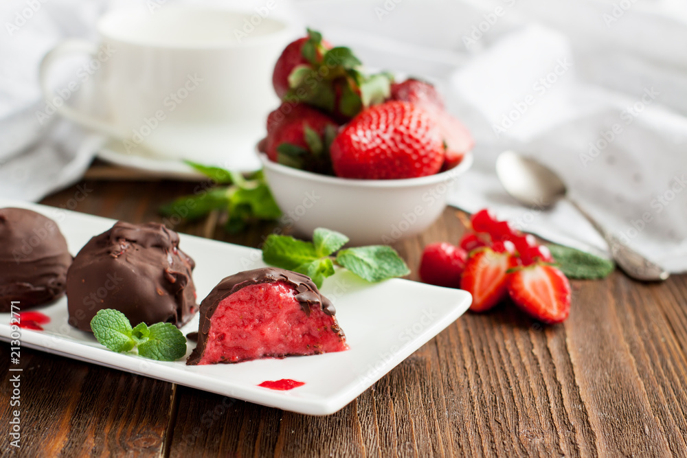 Strawberry ice cream balls in chocolate