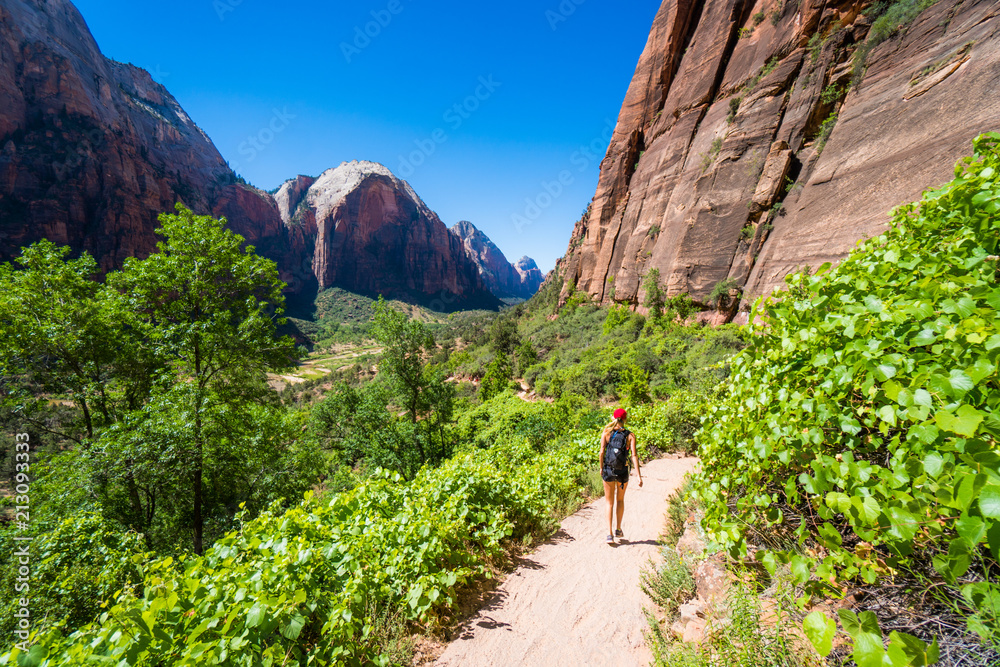 A woman hikes up a trail to Angel's Landing in Zion Utah