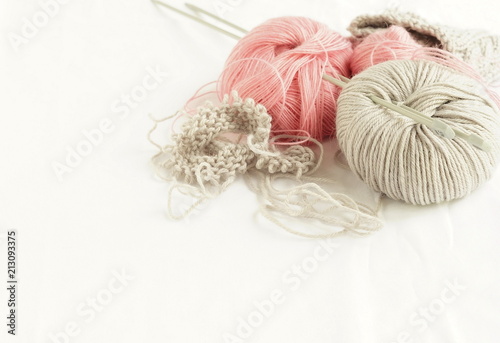 Grey and pink knitting wool and knitting needles on white background. top view.copy space.Close up
