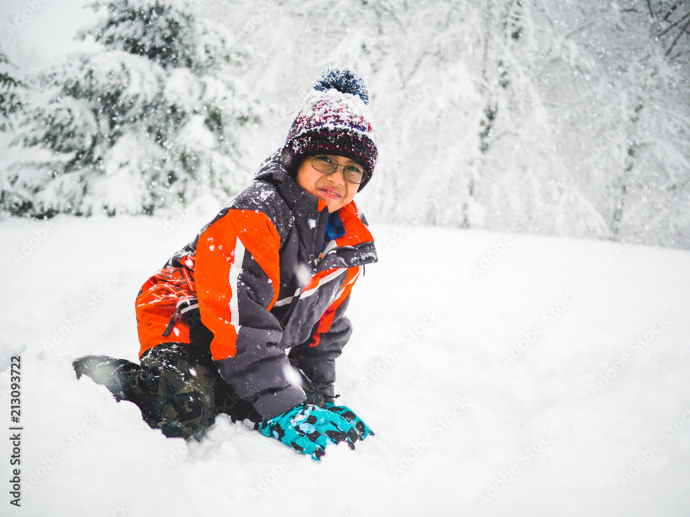 Boy with red jacket playing in the snow