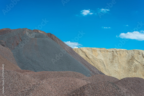 Heaps of gravel and crushed on blue sky at an industrial cement plant.