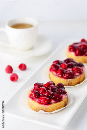 Tartlets with raspberries on a white plate