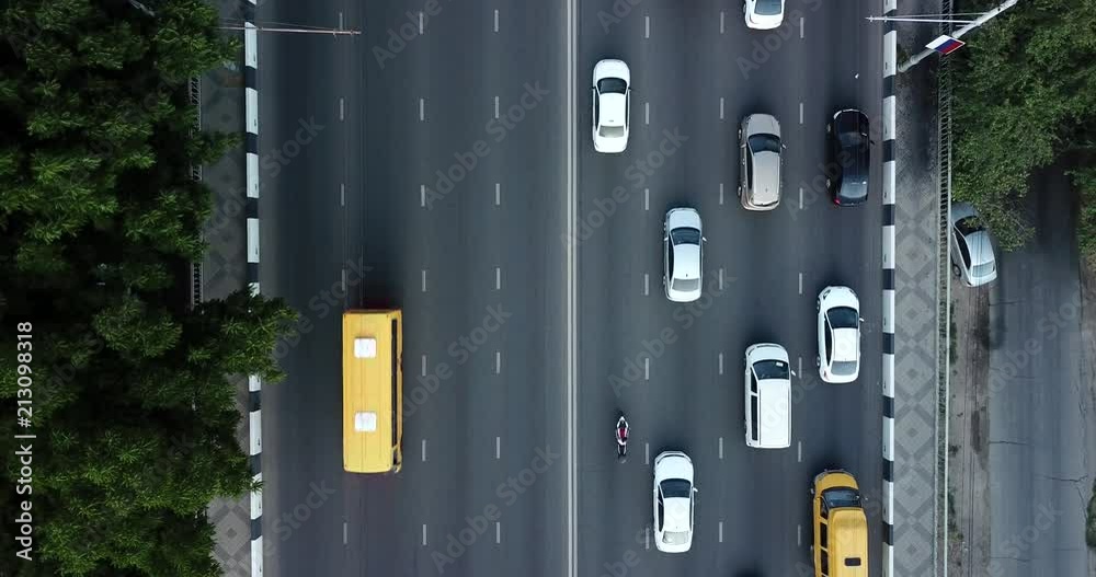 Aerial Drone Flight top down View of freeway busy city rush hour heavy traffic jam highway.  Aerial view of the vehicular intersection,  traffic at peak hour with cars on the road, over the bridge.