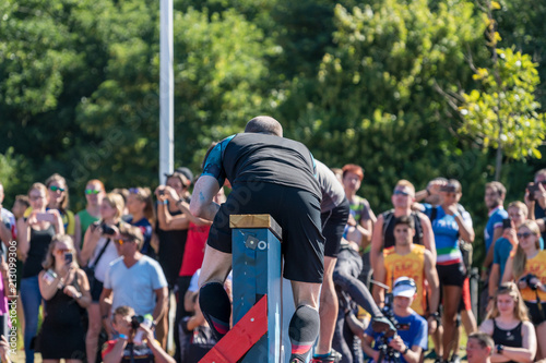 Athlet climbs above a wall at an obstacle course race