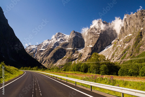 Trollveggen, the tallest vertical mountain face in Europe seen from road in morning sunlight, Rauma, Romsdal, Norway photo