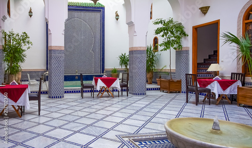 Courtyard decorated with mosaic and carvings in a Moroccan riad photo