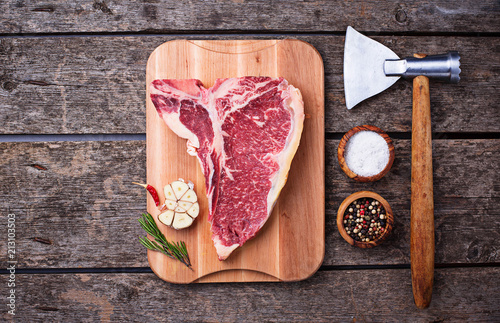 Raw T-bone steak with hatchet
