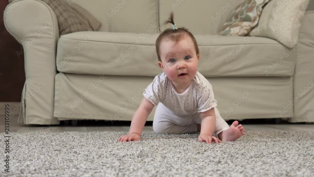 Cute clumsy baby smiling and looking at camera on floor at home Cute clumsy baby smiling and looking at camera on floor at home