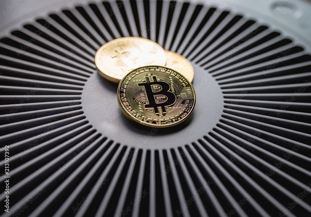 Bitcoin coin on cooling computer fan. Golden bitcoin on spinning blades of ventilator background. Bitcoin coin on cooling computer fan. Golden bitcoin on spinning blades of ventilator background.