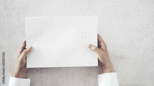 Hands holding white blank paper