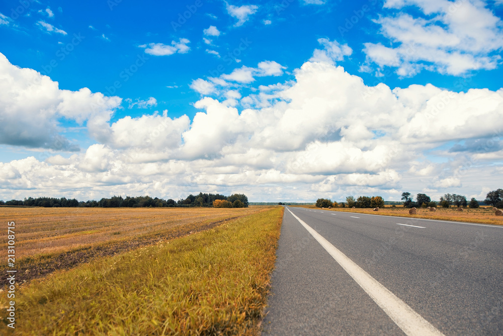Beautiful and sunny road landscape with sky clouds and yellow fields Beautiful and sunny road landscape with sky clouds and yellow fields