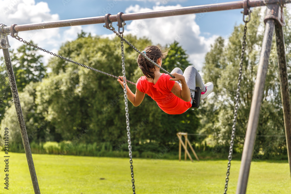 A girl swings peacefully on a large swing A girl swings peacefully on a large swing