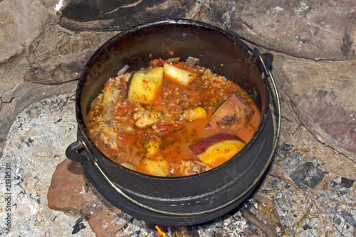 Stew made on three-legged pot on fire