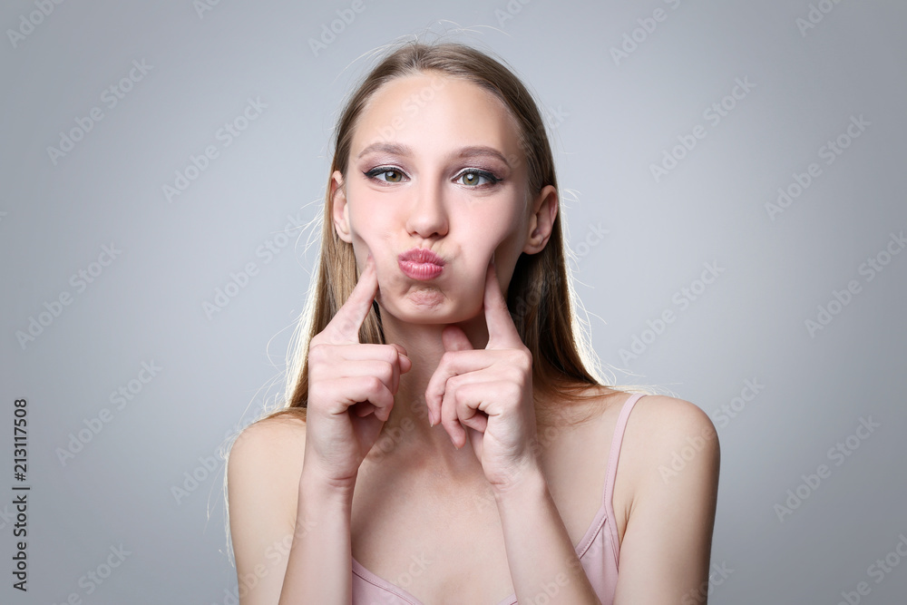 Portrait of young woman on grey background Portrait of young woman on grey background
