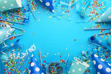 Birthday party caps, blowers and paper straws on blue background