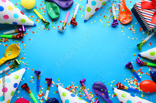 Birthday party caps, blowers and balloons on blue background