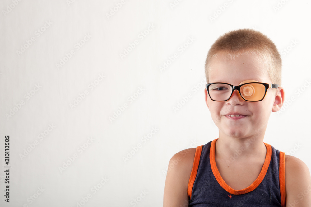 Child in glases with Occluder. Ortopad Boys Eye Patces nozzle for glasses for treating strabismus (lazy eye)