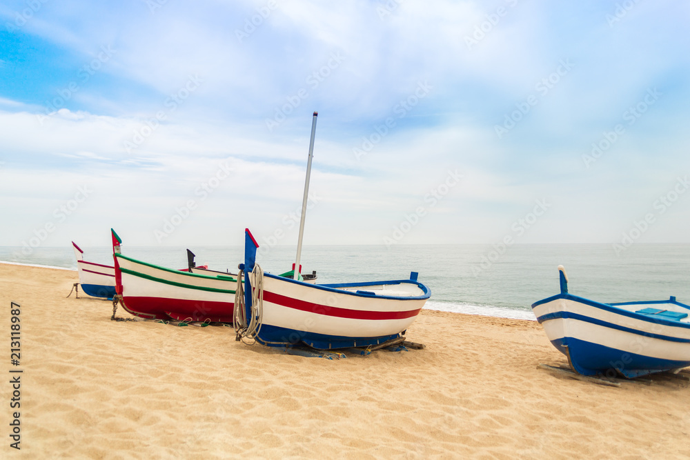 Several wooden fishing boats on a sandy beach in sunny day. Place for text