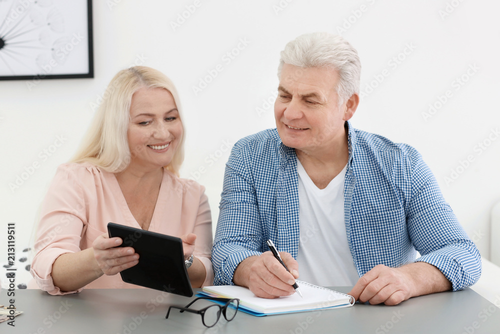 Mature couple thinking over pension payment at home Mature couple thinking over pension payment at home