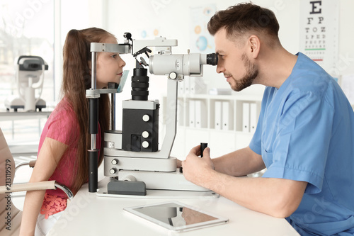 Ophthalmologist examining little girl in clinic