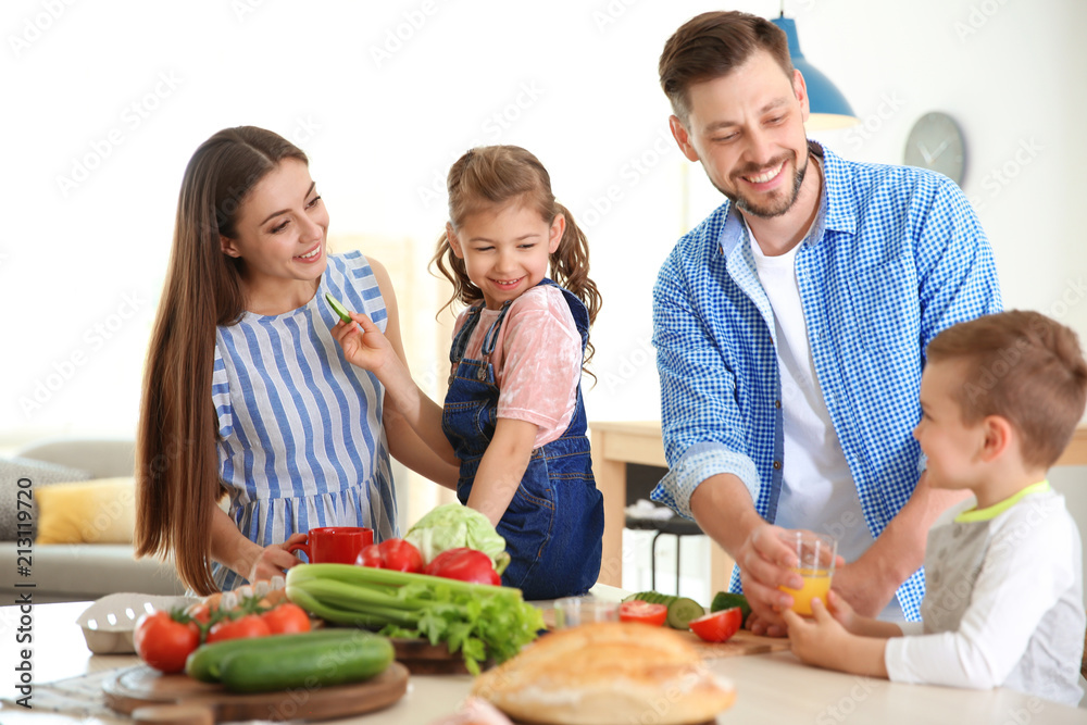 Happy family with children having breakfast in kitchen
