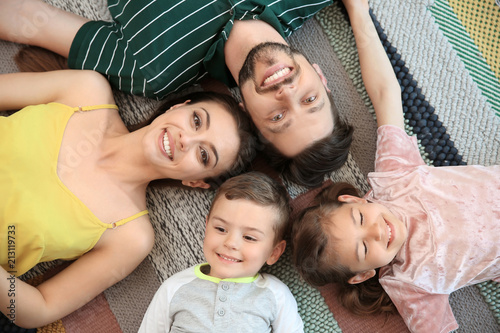 Portrait of happy family with children indoors  top view
