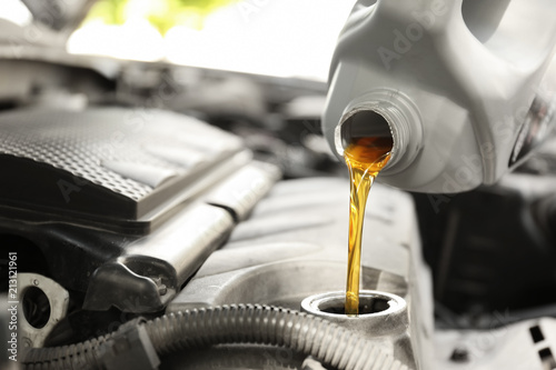 Pouring oil into car engine, closeup