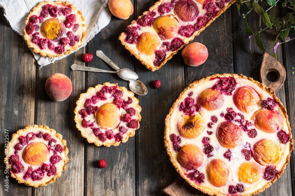 Rustic open pie with peach and raspberry, french galette . Peach tart. Raspberry tart. Tartalette with cream. Variety of bakery. Rustic open pie with peach and raspberry, french galette . Peach tart. Raspberry tart. Tartalette with cream. Variety of bakery.