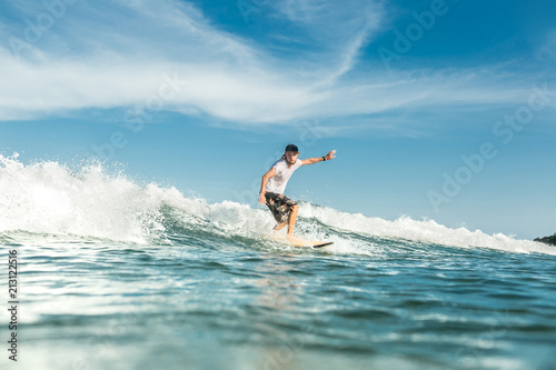 young male surfer riding waves in ocean at Nusa Dua Beach, Bali, Indonesia © LIGHTFIELD STUDIOS