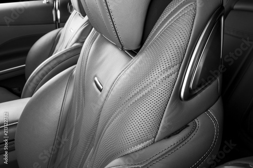 Modern Luxury car inside. Interior of prestige modern car. Comfortable leather red seats. Perforated leather cockpit. Modern car interior details. Black and white