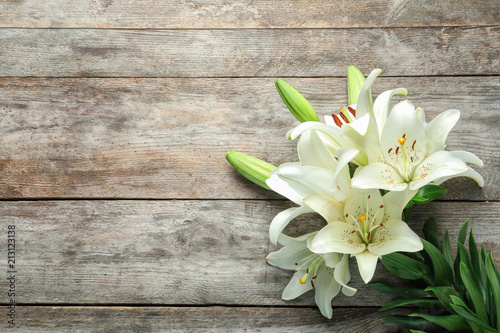 Flat lay composition with beautiful blooming lily flowers on wooden background photo