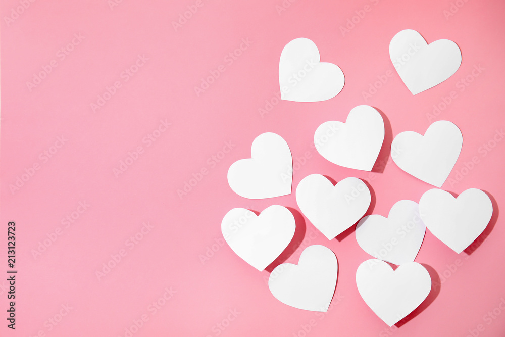 Small paper hearts on color background, top view