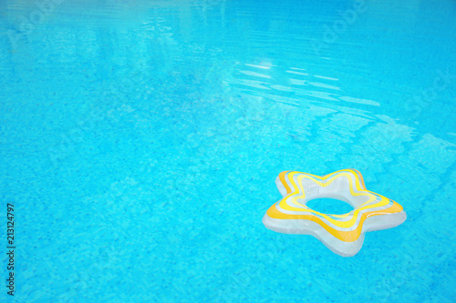 Inflatable colorful ring floating on water in swimming pool