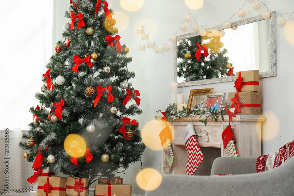 Stylish living room interior with decorated Christmas tree and blurred lights in foreground Stylish living room interior with decorated Christmas tree and blurred lights in foreground