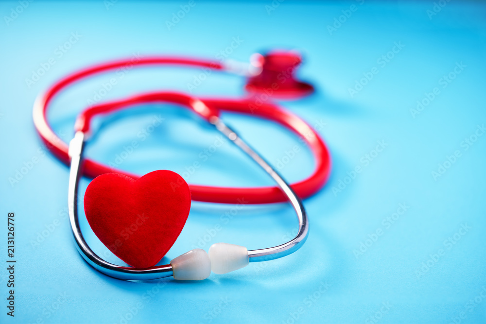 Red heart and stethoscope on on blue background.Selective focus. Red heart and stethoscope on on blue background.Selective focus.