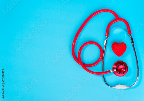 Red heart and stethoscope on on blue background.