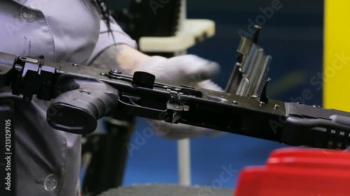 Weapon inspection. Female worker checks the weapons for defects. Close up view