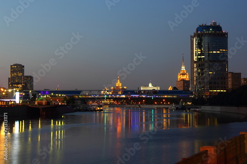 Russia, Moscow - night panoramic view from the quay of the Moscow river on the pedestrian bridge Bagration, empire building skyscraper and the Government house in the summer