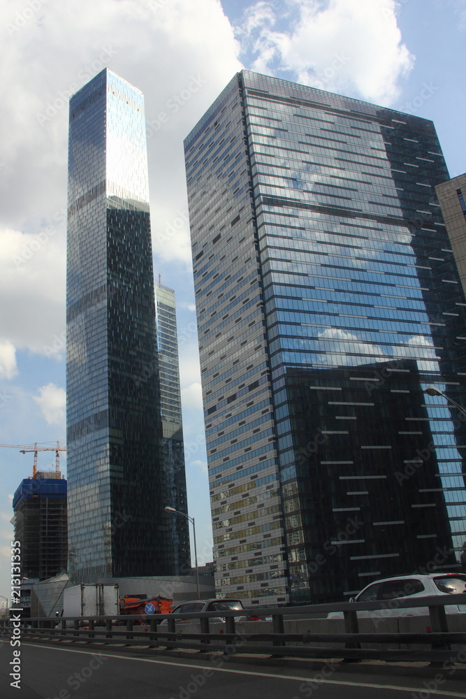 View from road of the glass skyscrapers in Moscow - business center Moscow city in the afternoon against the blue sky with clouds